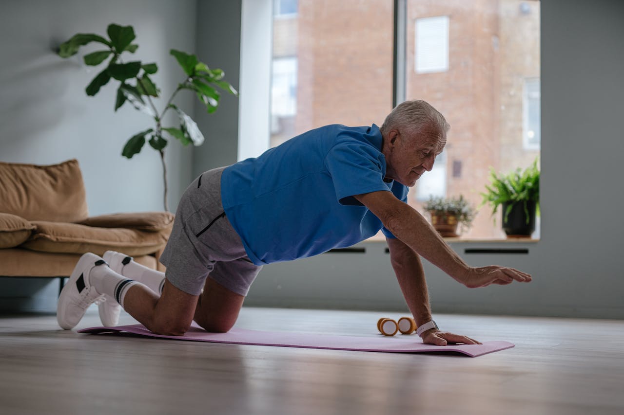 Elderly man exercising on a yoga mat at home, promoting a healthy lifestyle and wellness.